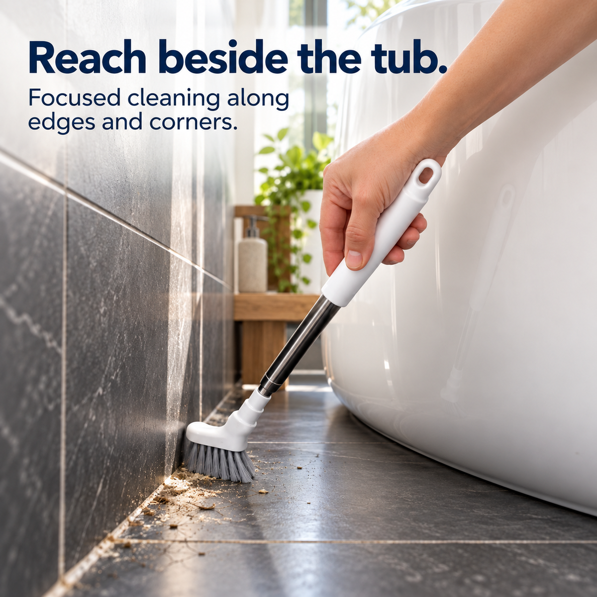 Crevice cleaning brush removing dirt along the narrow floor edge beside a bathtub