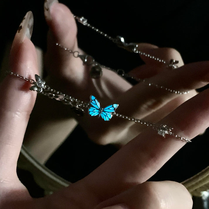 Luminous blue butterfly bracelet glowing in darkness