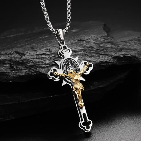 Close-up of Saint Benedict-inspired crucifix necklace on dark stone background
