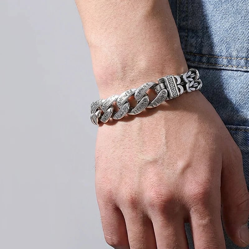 Close view of retro silver engraved bracelet links and braided chain