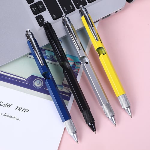 Multitool pens alongside a laptop and desk accessories