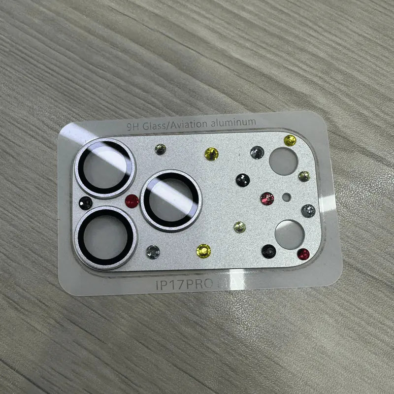 Silver camera lens protector showing the three circular lens openings and additional camera-related cutouts on its mounting backing